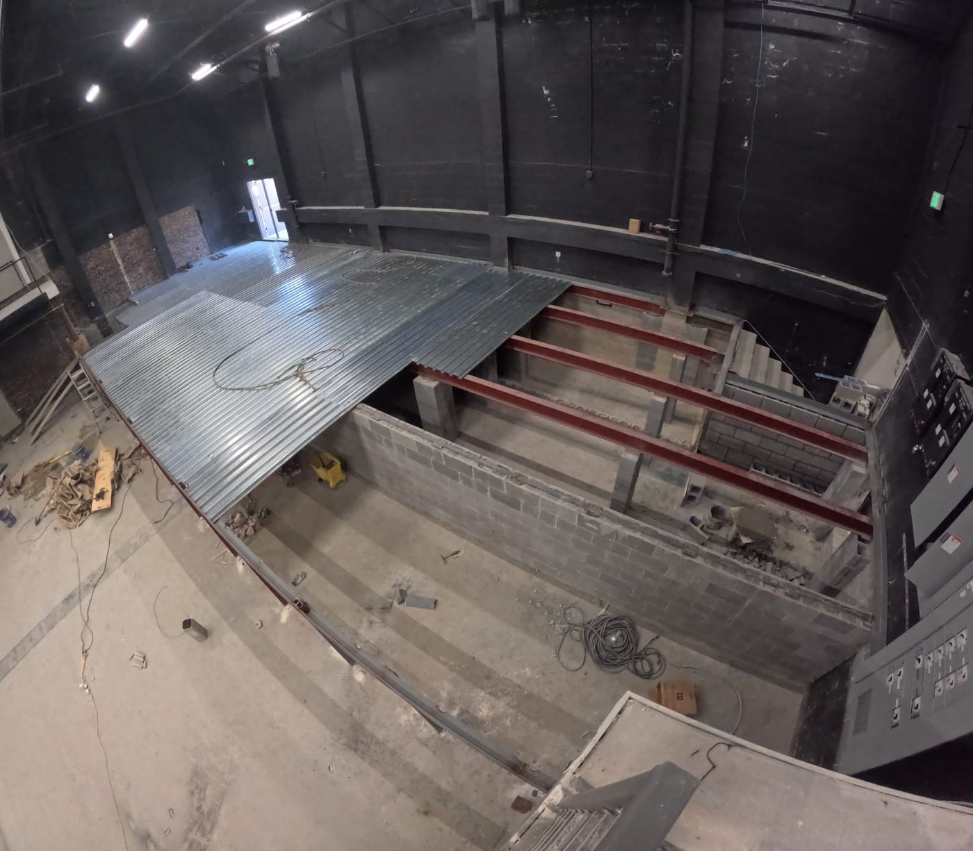 Two Dimes interior during construction, with steel beams and metal decking above masonry walls