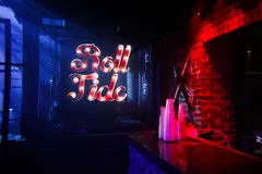 Brick wall, bar counter and illuminated Roll Tide sign inside Two Dimes