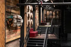 Completed Two Dimes seating levels with red benches, timber walls and floors, black railings and a decorative vintage truck front